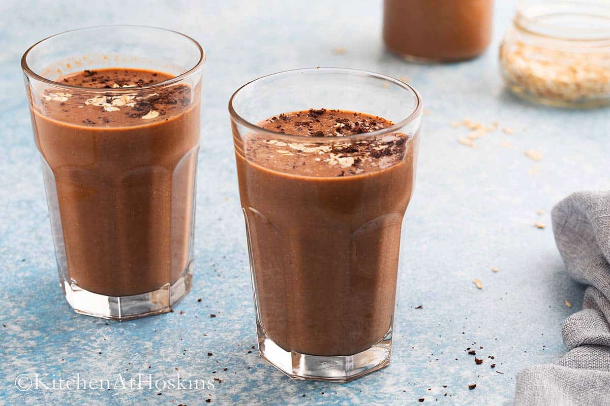 chocolate shake in tall glasses garnished with oats.