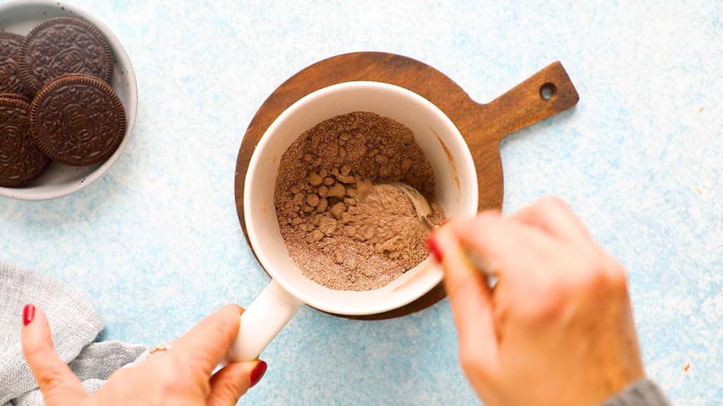 mixing dry ingredients in a coffee mug with a spoon.
