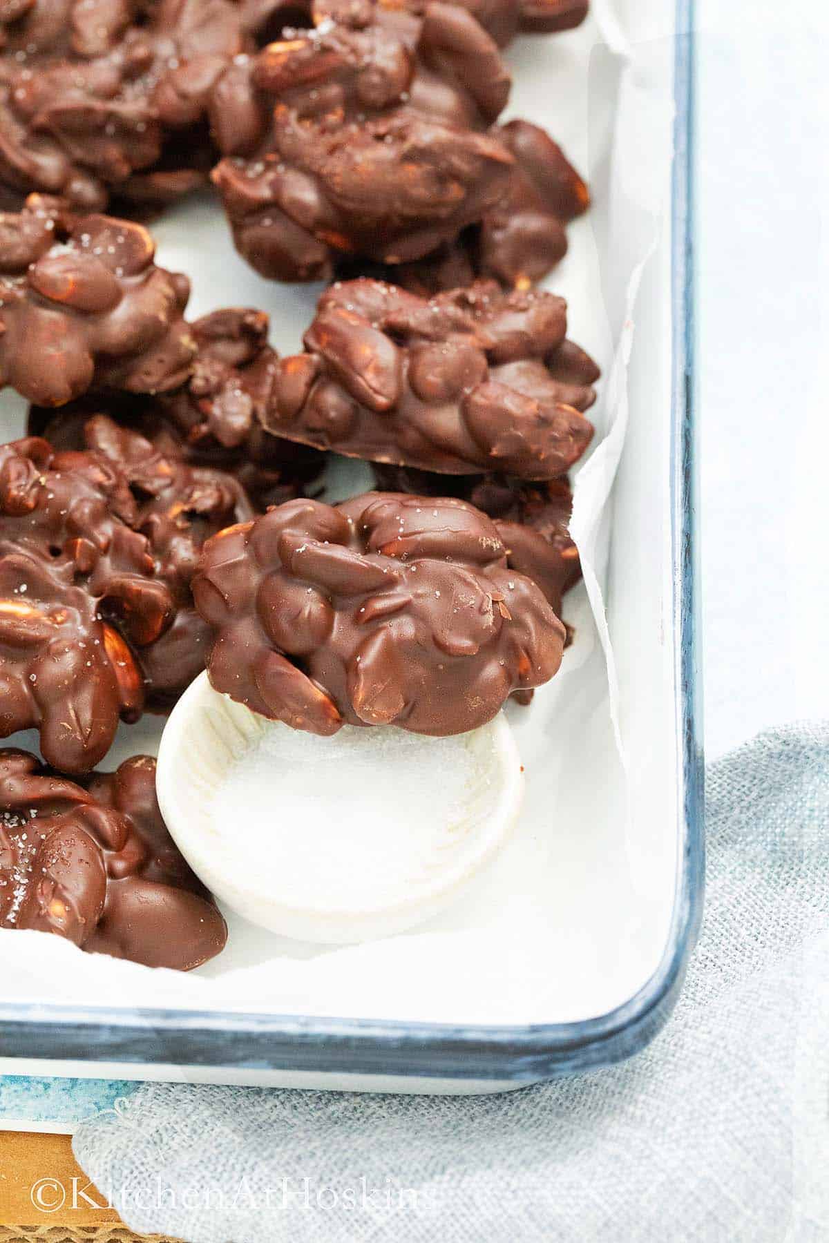 white metal tray filled with chocolate peanut cluster candy.