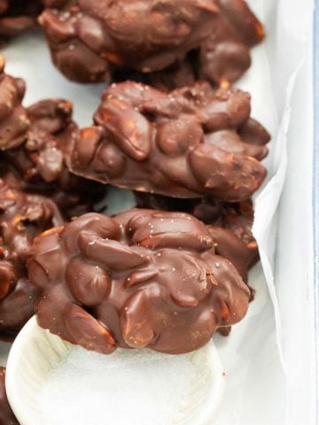chocolate peanut clusters on a tray sprinkled with salt.