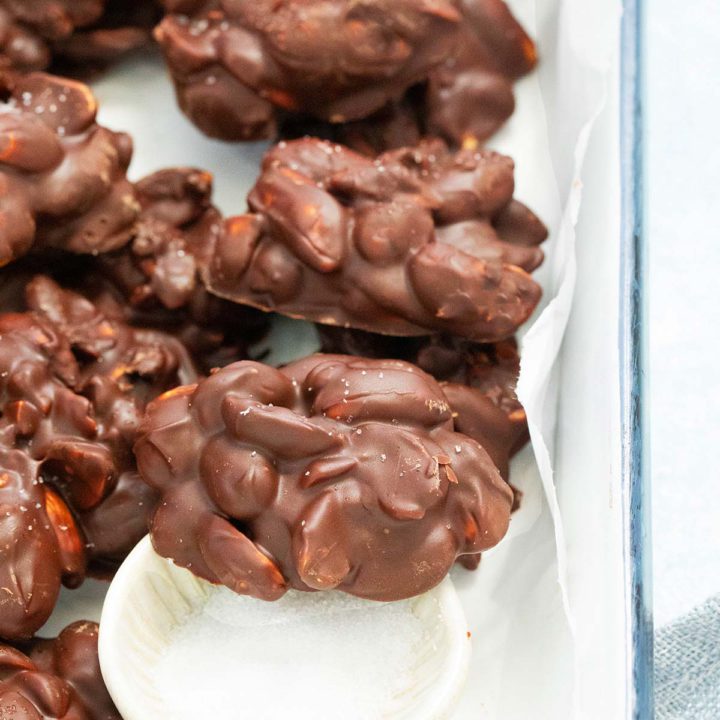 chocolate peanut clusters on a tray sprinkled with salt.