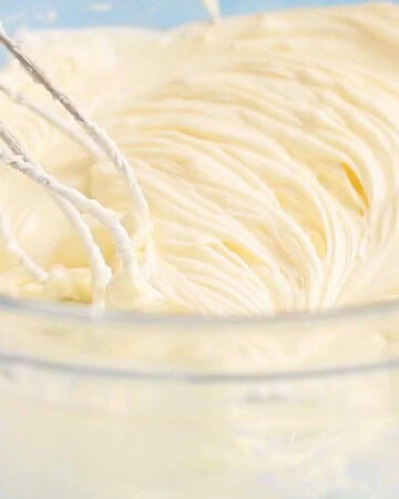 whipped white cream cheese filling in a large glass bowl.