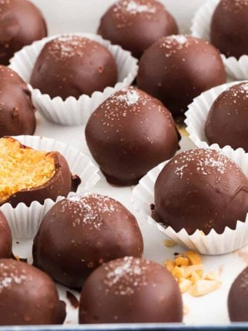 chocolate coated peanut butter balls on a white tray.