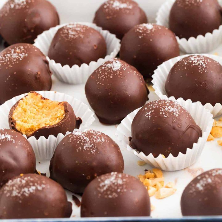 chocolate coated peanut butter balls on a white tray.