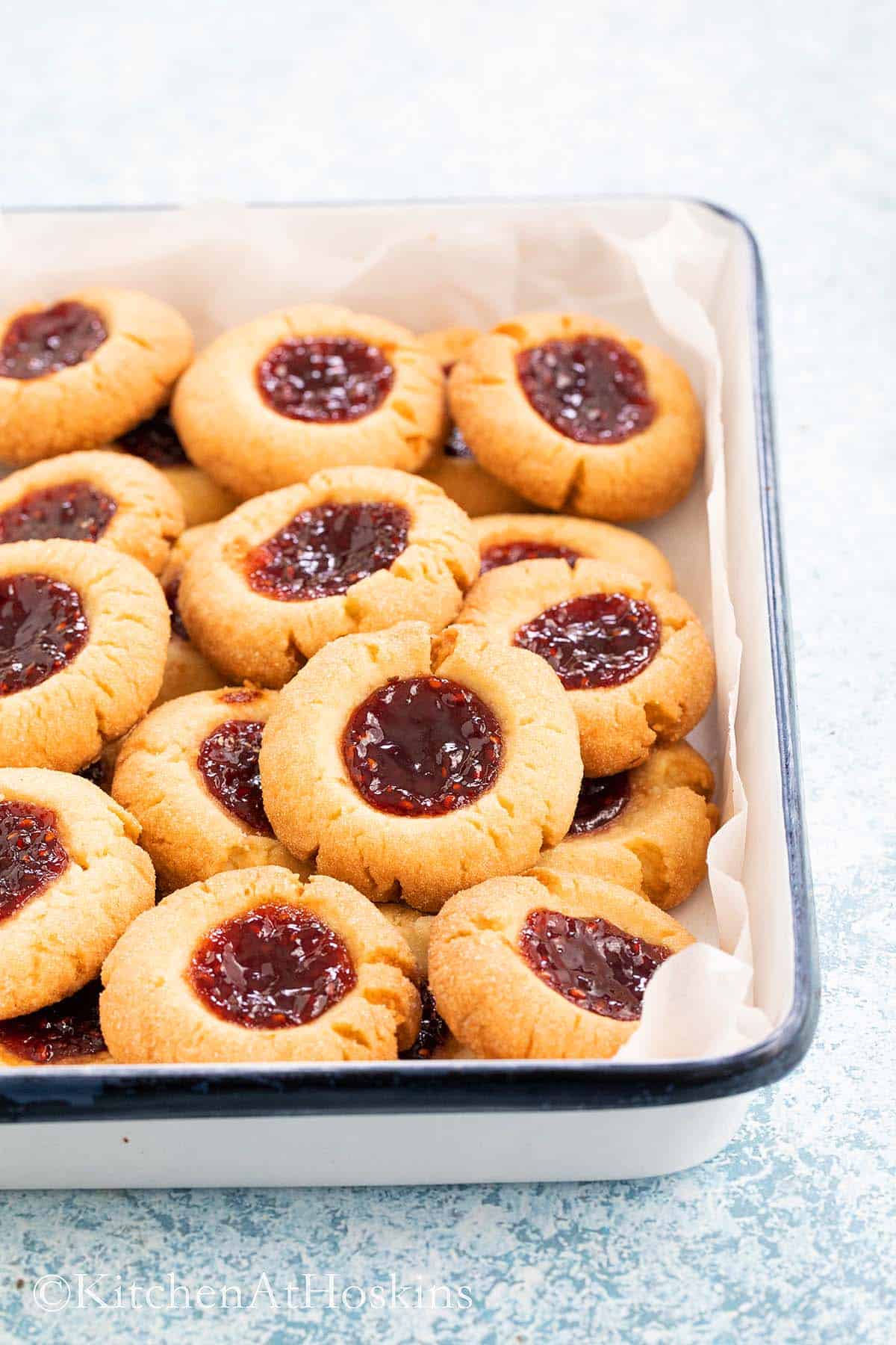 a white tray with jam filled cookies.