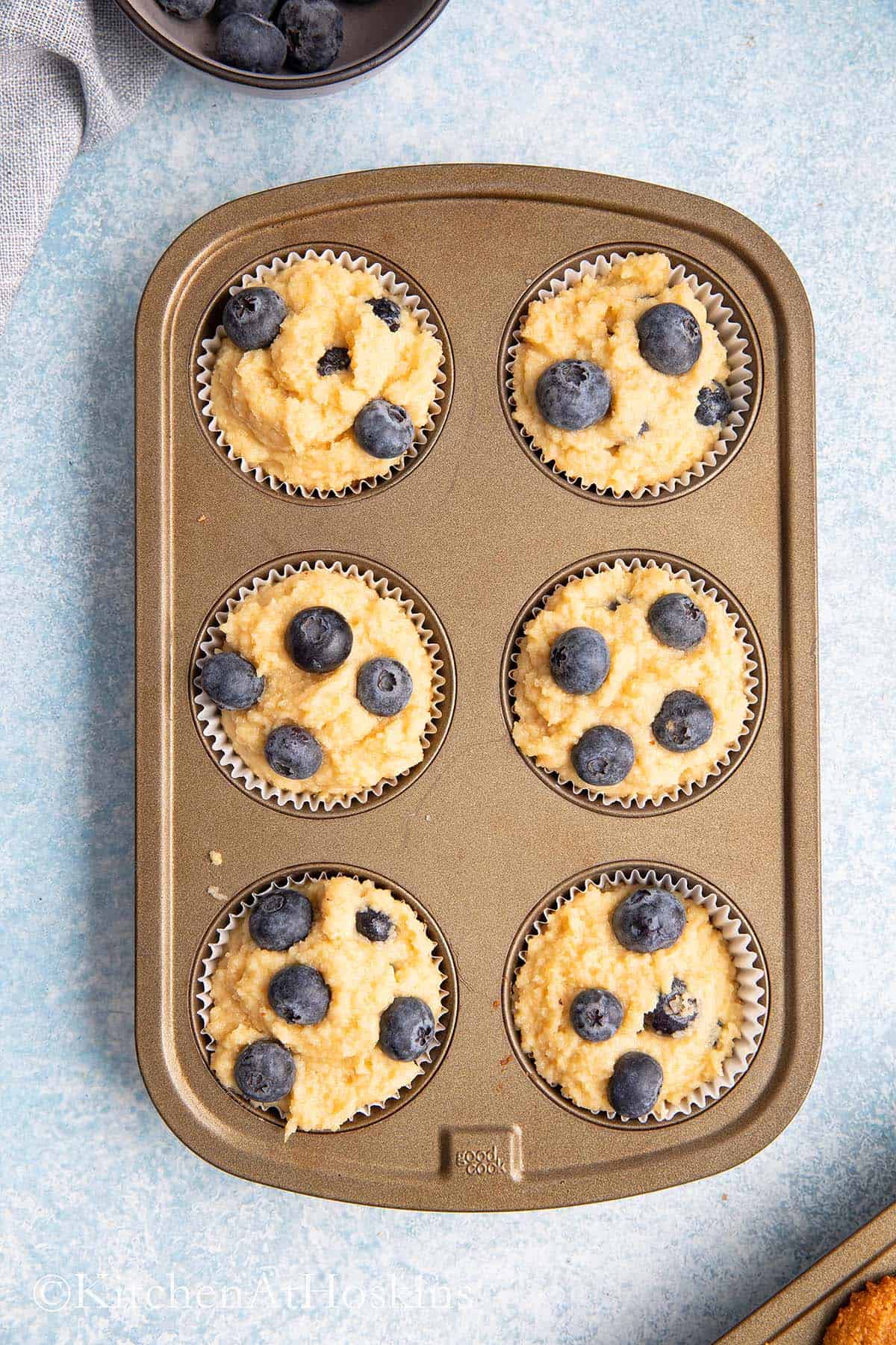 blueberry muffin batter in a muffin pan.