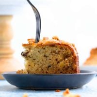 a slice of banana cake in a blue plate along with a fork.