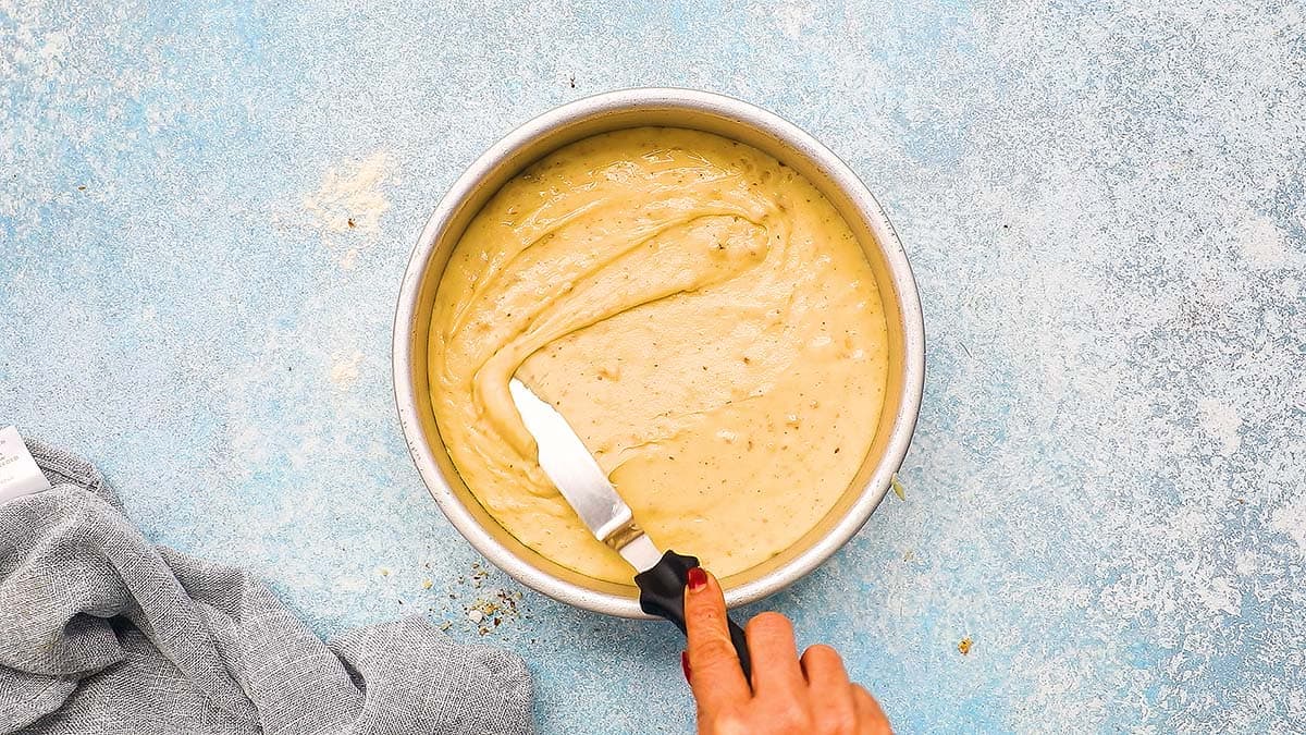 spreading cake batter in a baking pan with a flat spatula.