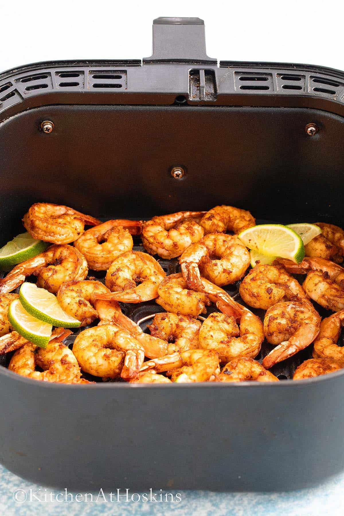 air fryer basket with cooked shrimp.