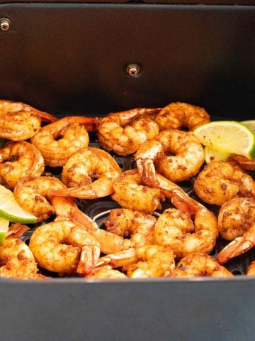 air fryer basket with cooked shrimp.