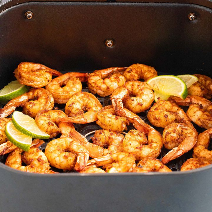 air fryer basket with cooked shrimp.
