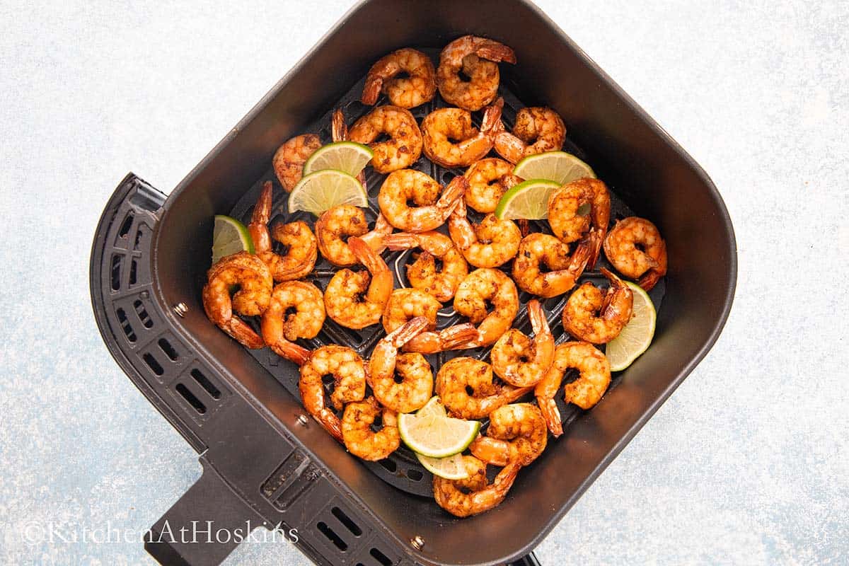 cooked shrimp in an air fryer basket.