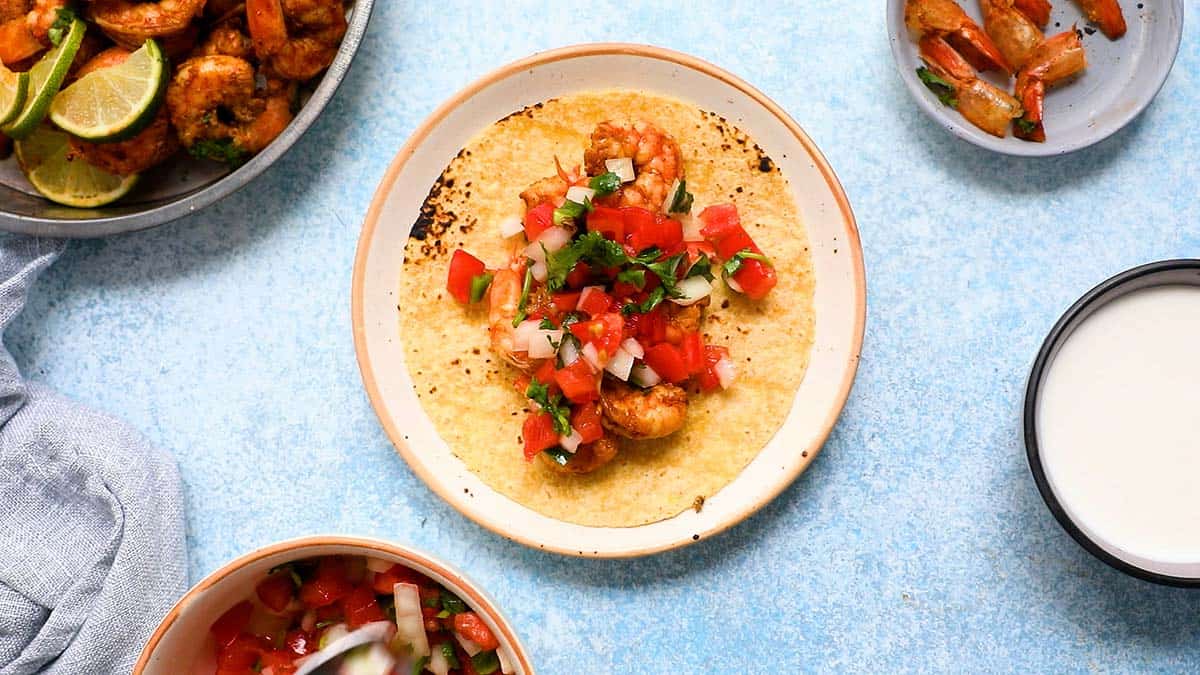 tortilla topped with shrimp and pico de gallo.