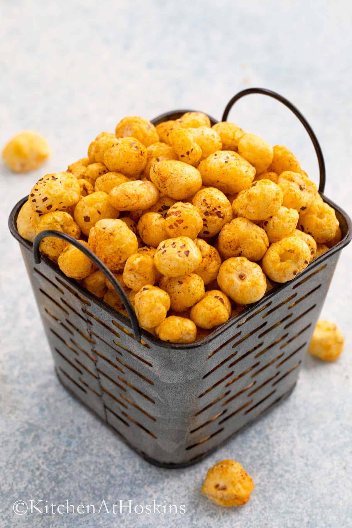 spicy roasted phool makhana piled high in a metal basket.