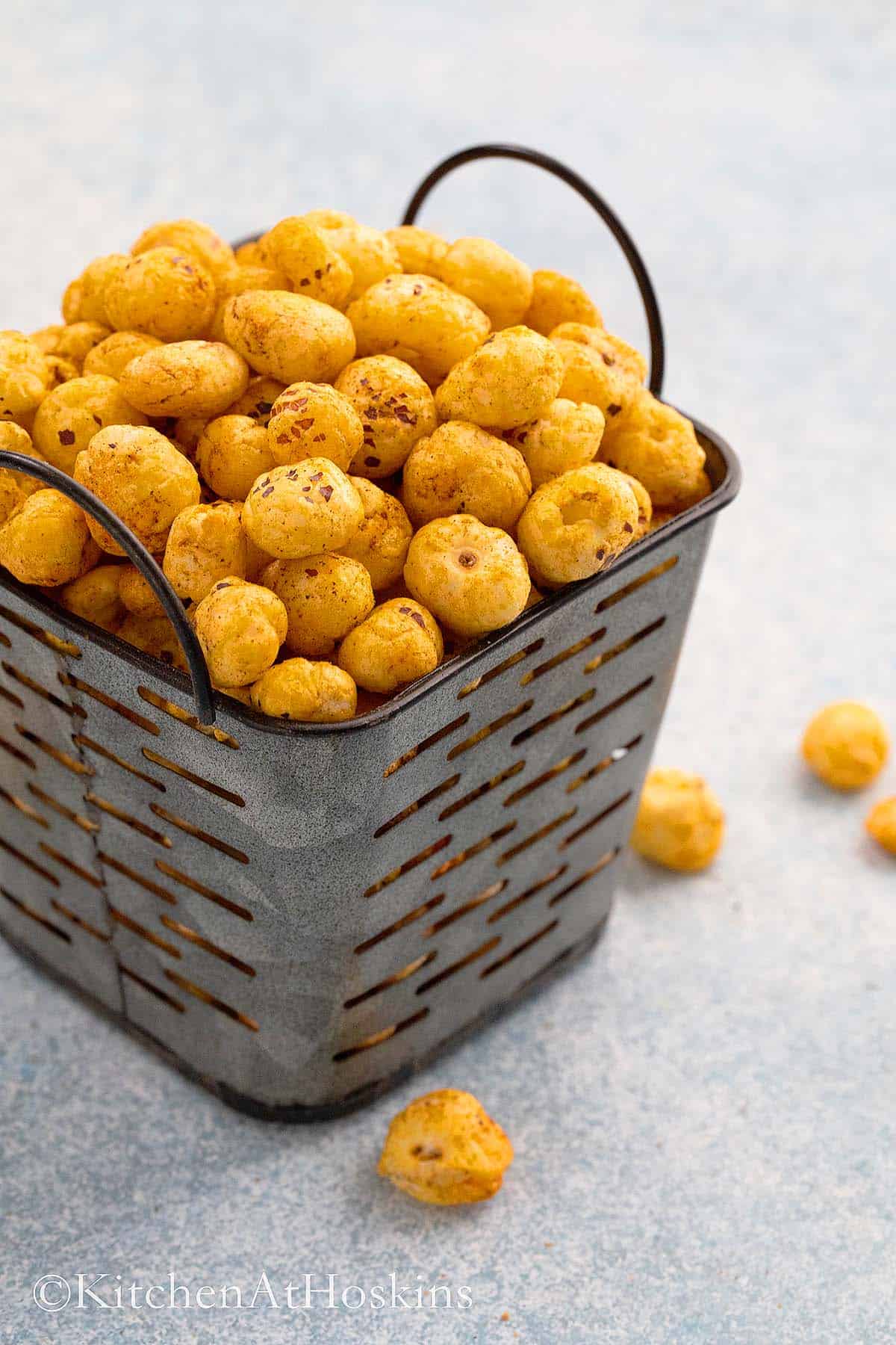 roasted fox nuts piled high on a metal basket.