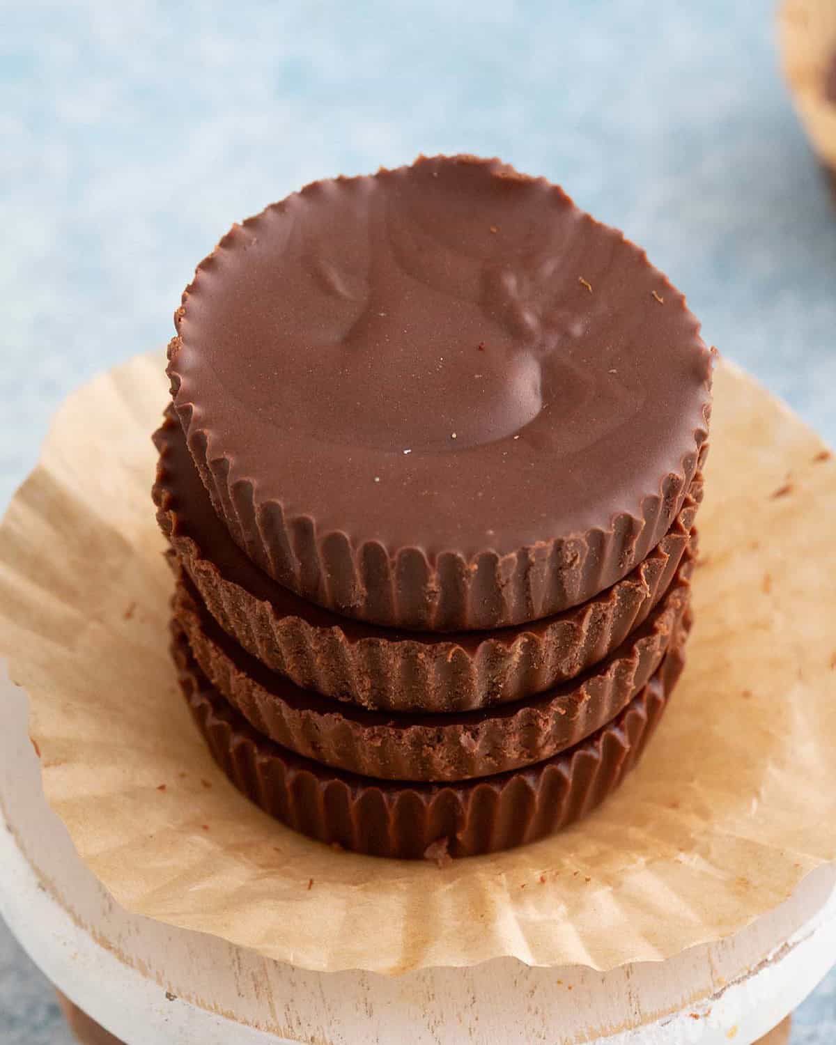 4 brown sunbutter cups stacked on a small white board.