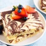 2 square marbled pancakes with berries on a white plate.
