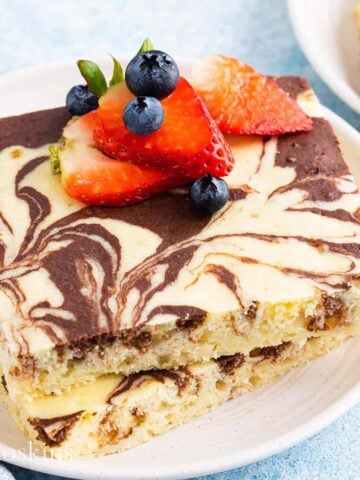 2 square marbled pancakes with berries on a white plate.