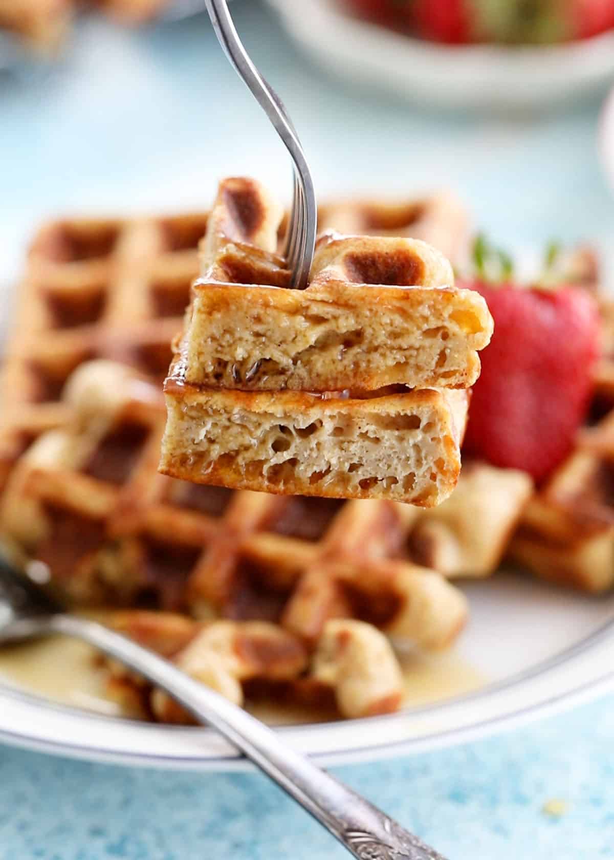 a metal fork holding two pieces of healthy waffles.