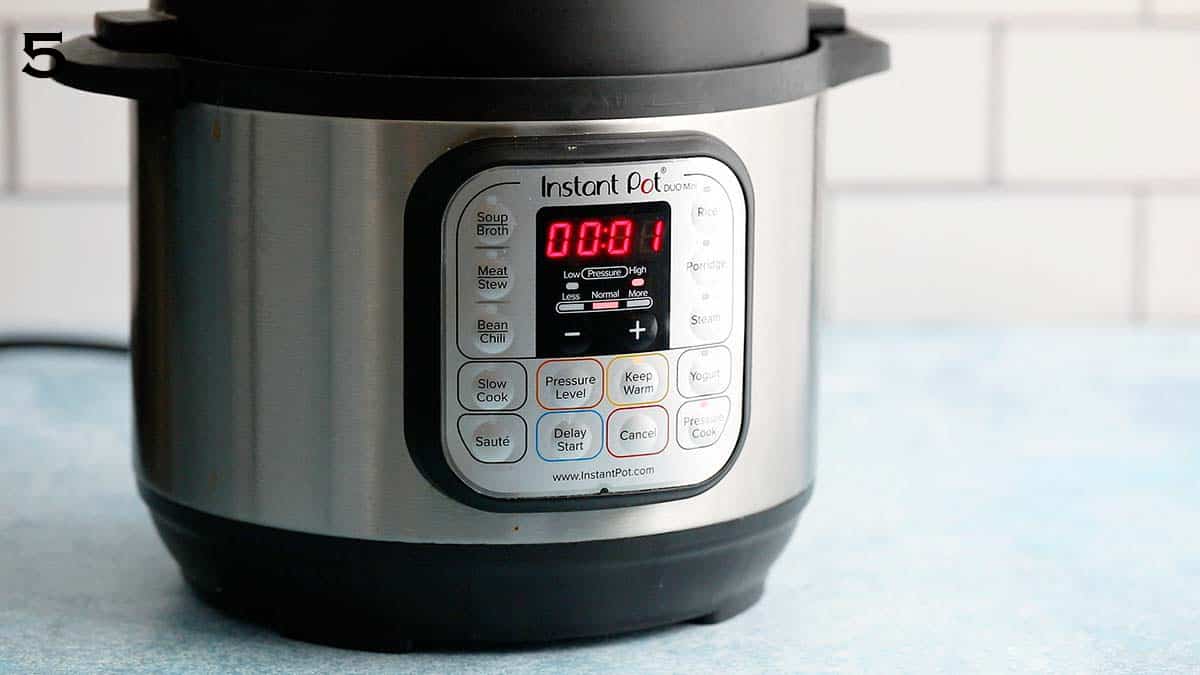 an instant pot displaying 1 minute.