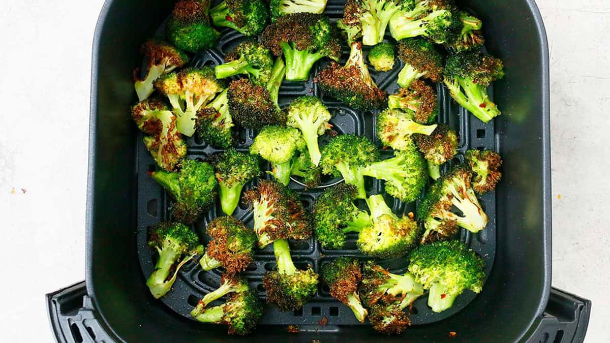 air fried broccoli in a black basket.