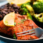 air fryer salmon with green broccoli in a black plate.