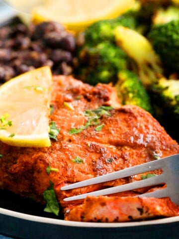 air fryer salmon with green broccoli in a black plate.