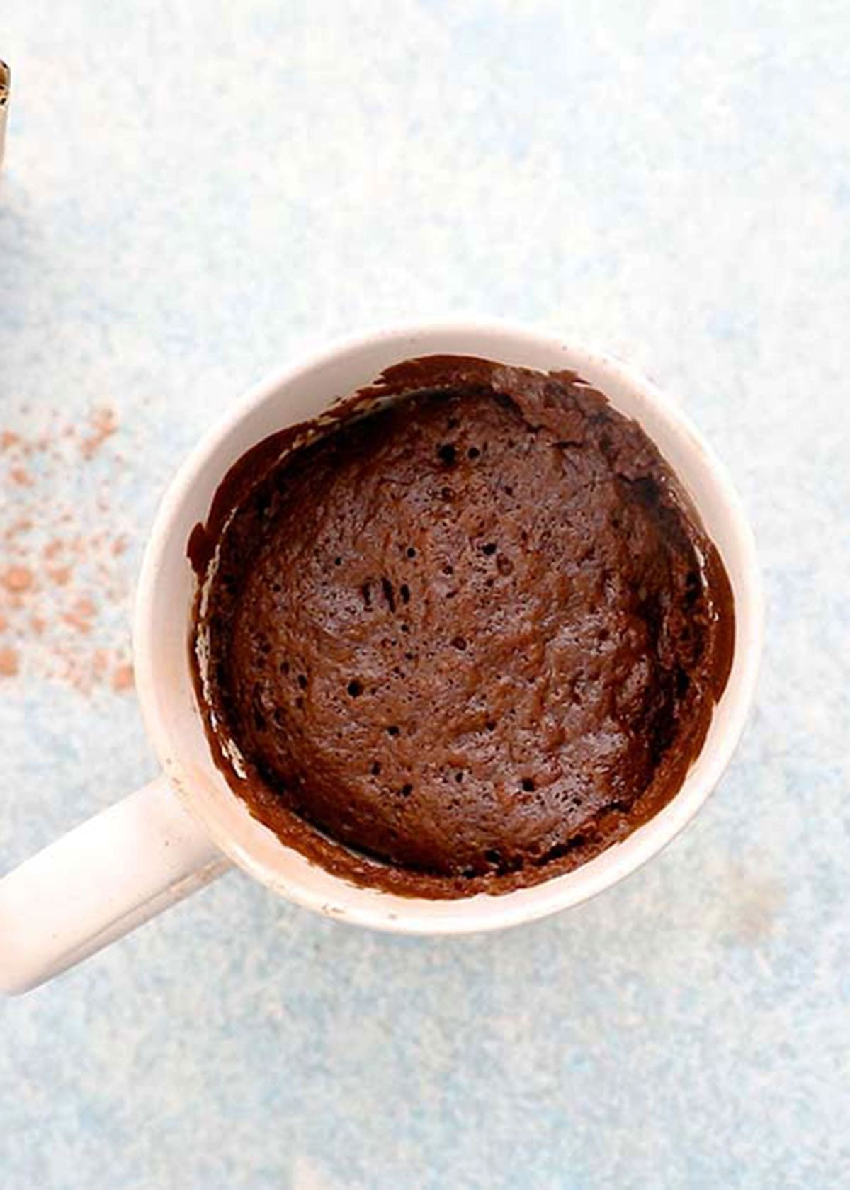 baked chocolate cake in a white mug.