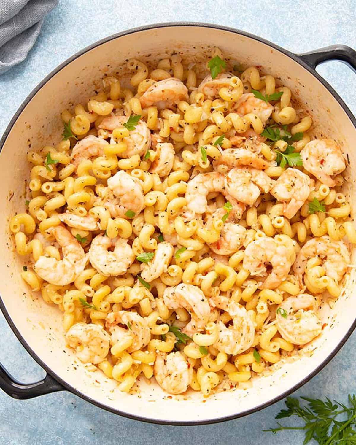 cooked shrimp and pasta in a yellow pan.