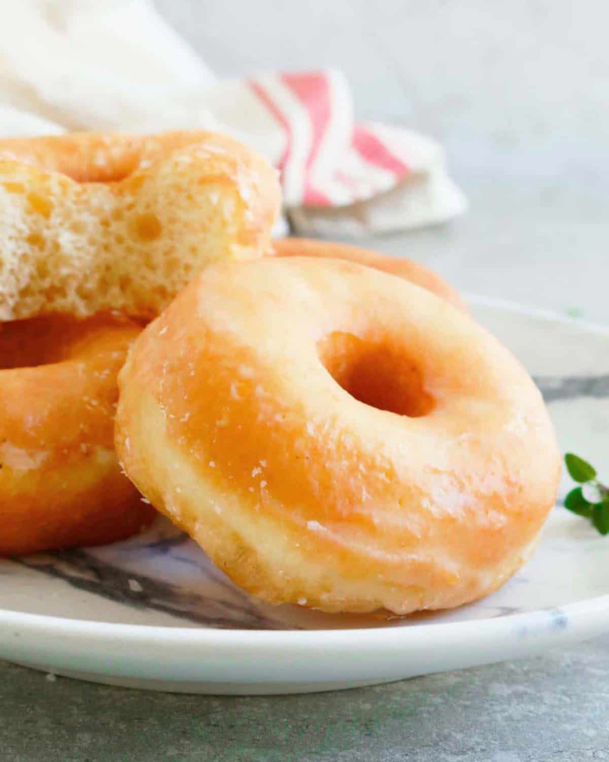 three donuts in a white plate.