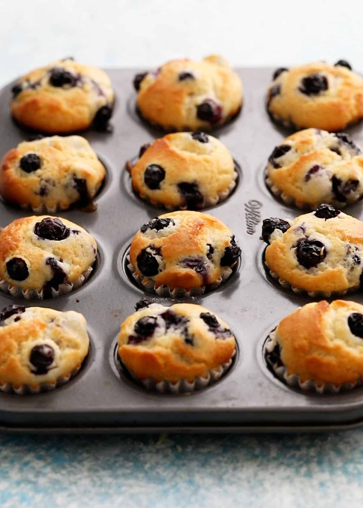 mini blueberry muffins in a metal muffin pan.