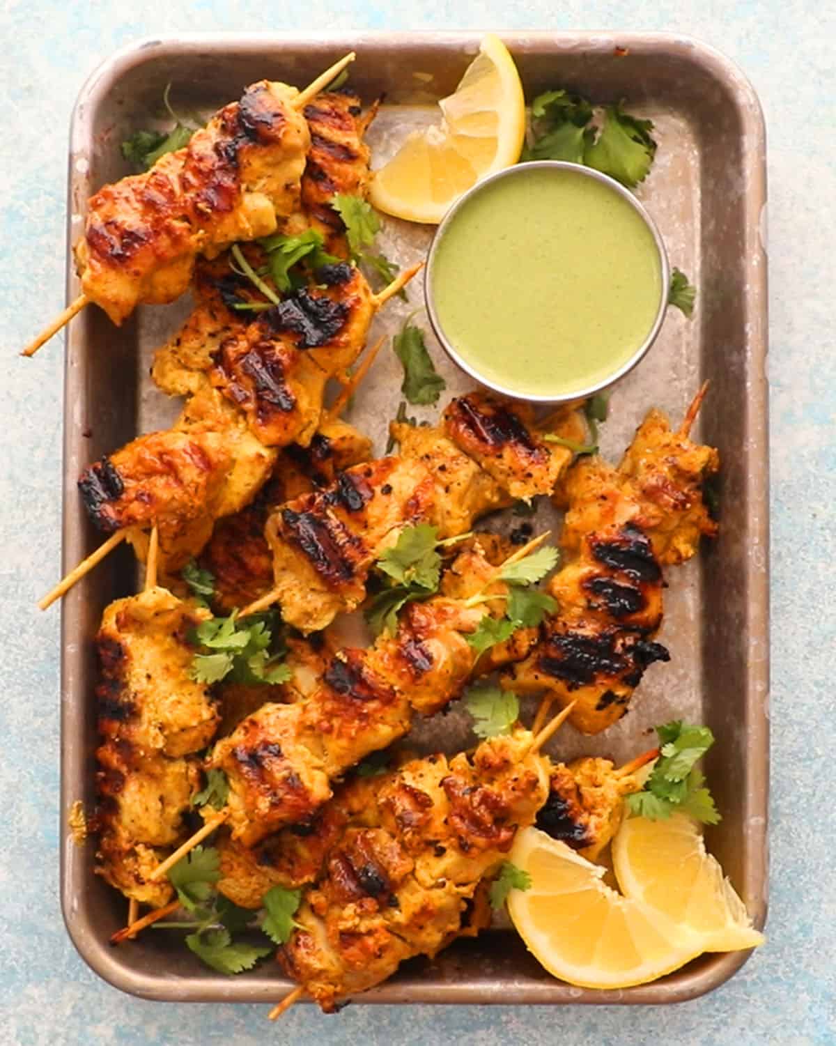 cooked chicken kebabs in a metal plate.