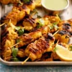 cooked chicken kebabs in a metal plate.