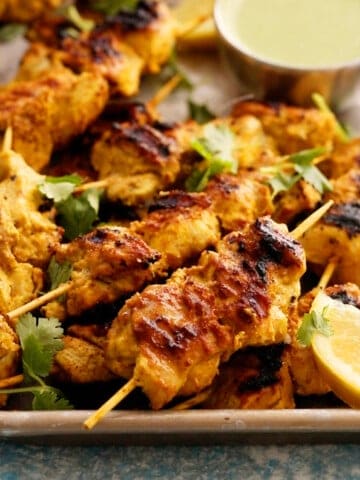 cooked chicken kebabs in a metal plate.