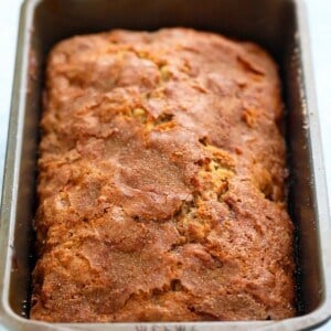 a metal loaf pan with baked apple bread.