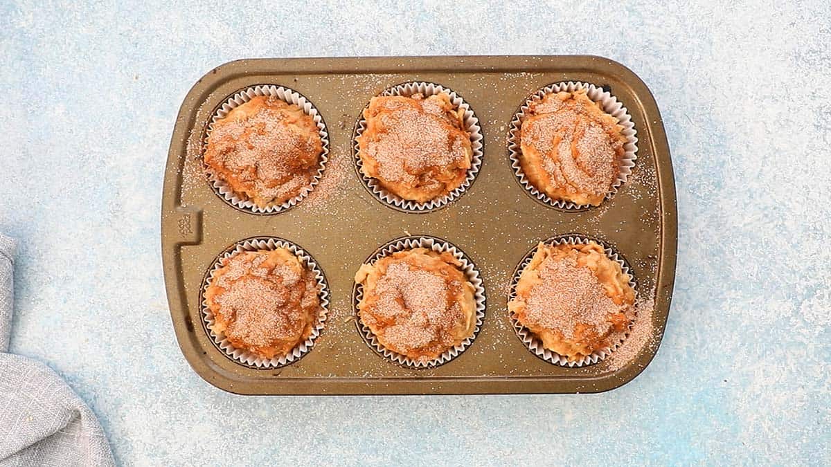 a 6-cup metal muffin pan with batter ready to be baked.