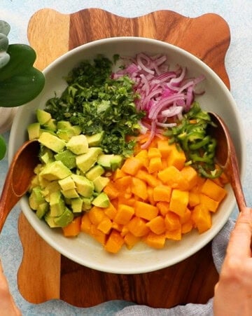 yellow and green mango avocado salsa in a white bowl.