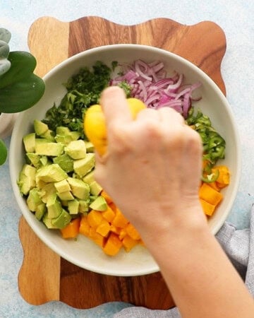 yellow and green mango avocado salsa in a white bowl.