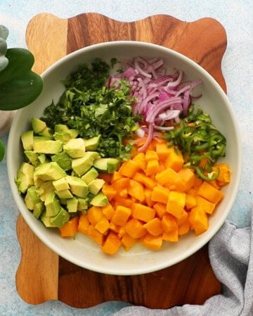 yellow and green mango avocado salsa in a white bowl.