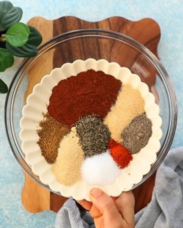 different colored spices in a white plate.