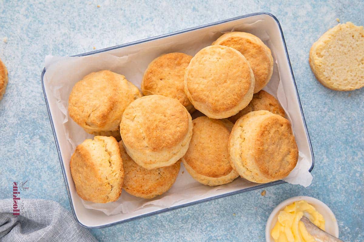 a white metal tray with baked cream biscuits.