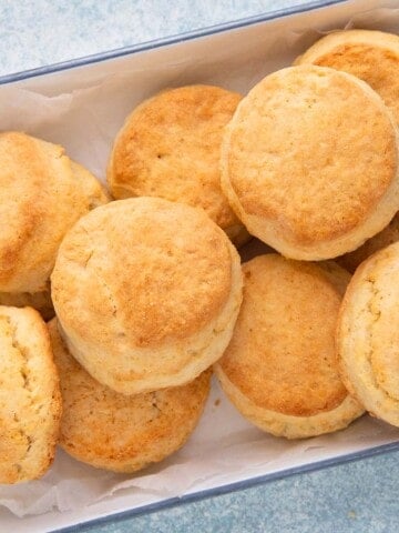 baked cream biscuits on a white metal tray.