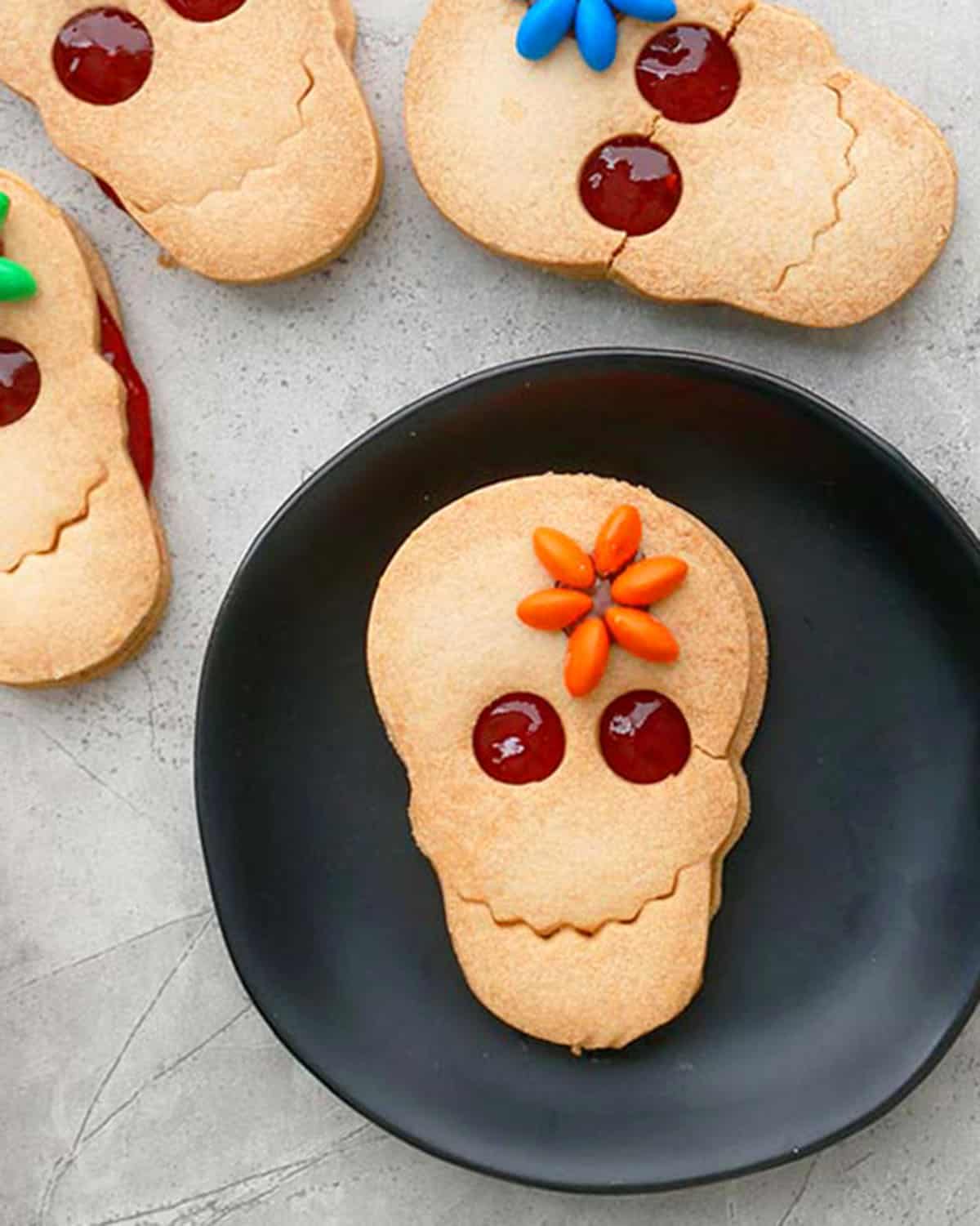 skull shaped Halloween cookies in a black plate.