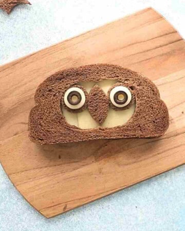 one brown grilled cheese sandwich on a wooden board.