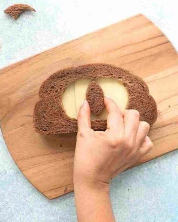 one brown grilled cheese sandwich on a wooden board.
