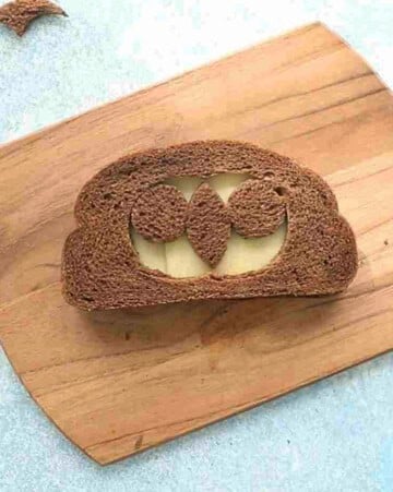one brown grilled cheese sandwich on a wooden board.