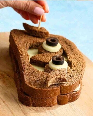 one brown grilled cheese sandwich on a wooden board.