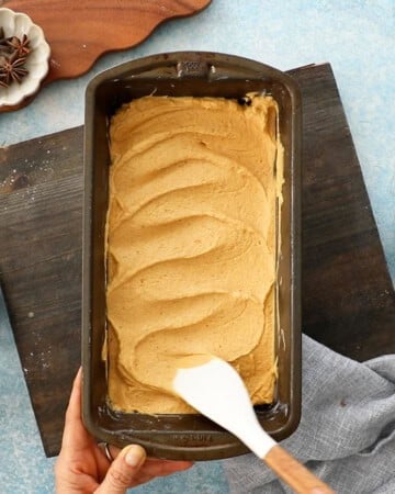 pumpkin cake batter in a metal baking pan.