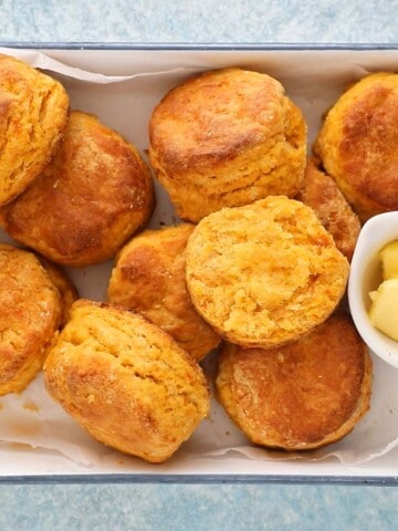 sweet potato biscuits on a white tray along with a small white bowl with butter.