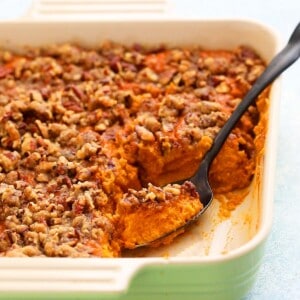 a spoonful of sweet potato souffle in a ceramic square dish.